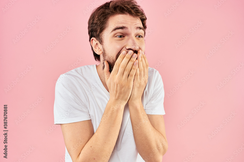 Man in white t-shirt gestures with hands emotions lifestyle cropped view pink background Man in white t-shirt gestures with hands emotions lifestyle cropped view pink background