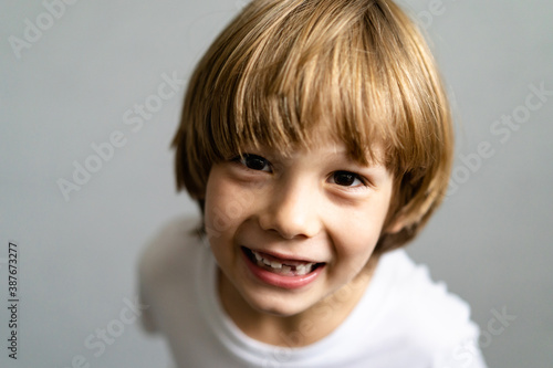 cute emotional disheveled boy without teeth, baby teeth fell out, children's medicine concept dentistry