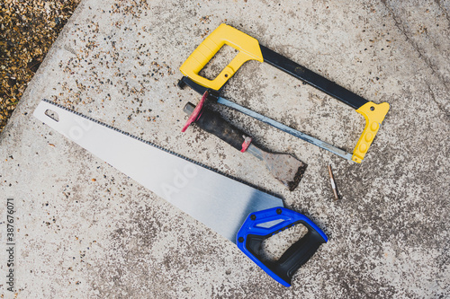 saws with chisel and diy tools on concrete surface outdoor photo