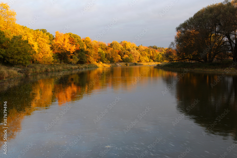 The sunrising on the autumn coloredd trees lining the Grand River. Shot in Waterloo, Ontario, Canada. The sunrising on the autumn coloredd trees lining the Grand River. Shot in Waterloo, Ontario, Canada.
