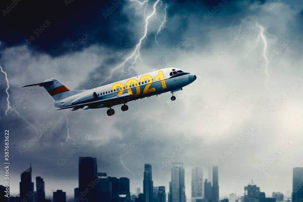 Airplane with numbers 2021 fly under storm clouds Airplane with numbers 2021 fly under storm clouds
