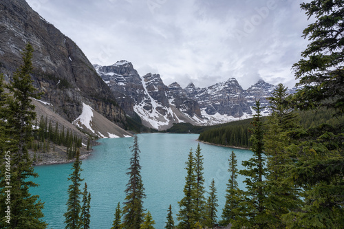 View on beautiful alpine lake with turquoise waters surrounded by magnificent peaks, high perspective shot made on a overcast day at Moraine Lake, Banff National Park, Alberta, Canada