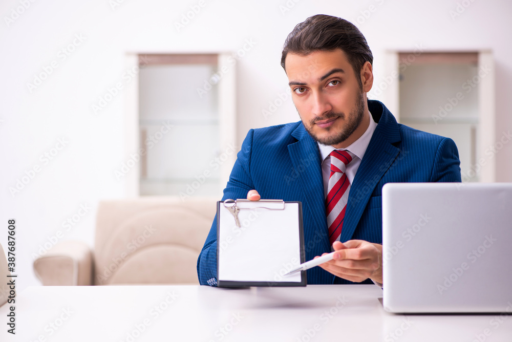Handsome male realtor working indoors Handsome male realtor working indoors