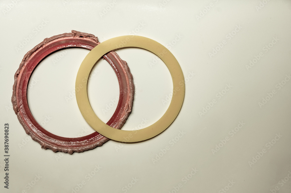 Old and new seal gasket from the flapper mechanism of a leaky residential bathroom toilet