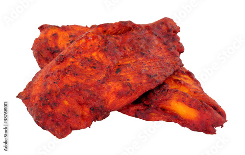 Chicken Tikka chicken breast thins marinated in mild spice blend isolated on a white background