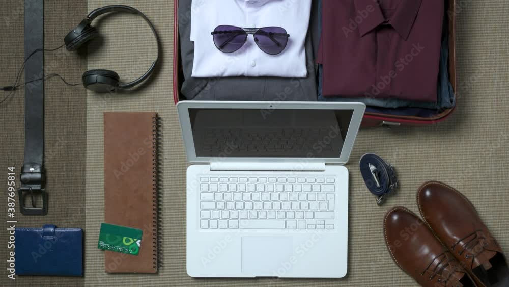 Man getting ready for a trip and working on laptop Man getting ready for a trip and working on laptop