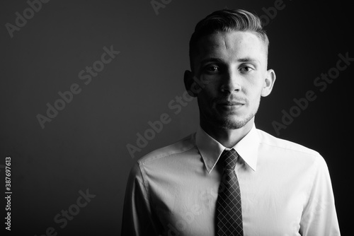 Portrait of young businessman against gray background photo