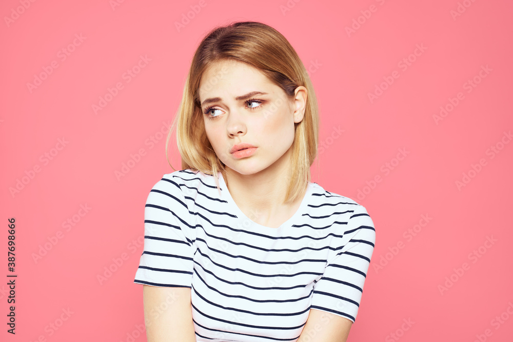 Woman in striped t-shirt emotions studio cropped view lifestyle pink isolated background Woman in striped t-shirt emotions studio cropped view lifestyle pink isolated background
