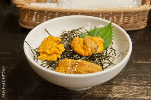 Premium supreme delicious fresh from the sea 3 types of uni sea urchin sashimi on top of warm steamed rice with crispy grilled seaweed.