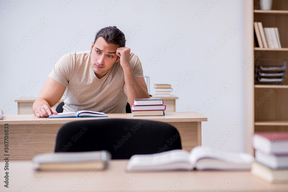 Young male student preparing for exams at library - obrazy, fototapety, plakaty 