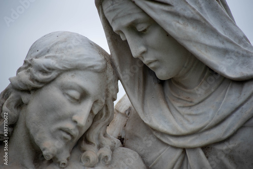 Close up of Jesus and Mary in cemetery pieta statue. Full frame in matural light with copy space photo