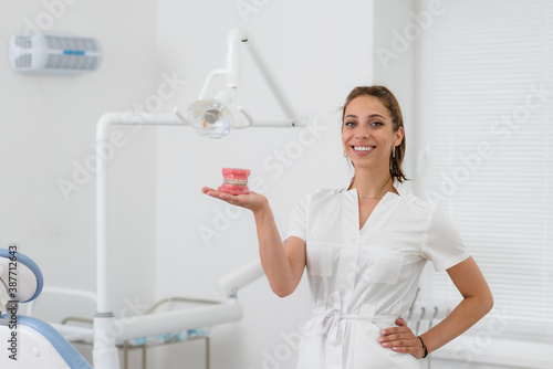 doctor orthodontist holding a model of the jaw with braces