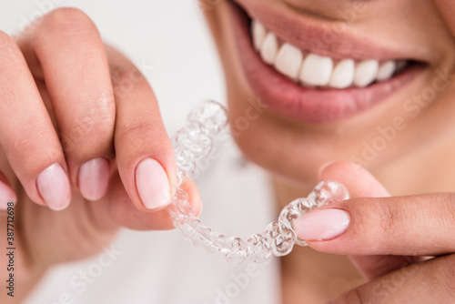 girl with a beautiful smile holding a transparent mouth guard photo