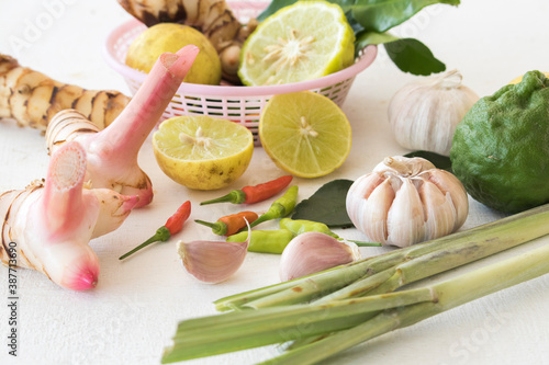 garlic ,bergamot,lemon,lemon glass,pepper,galangal and lime leaf herbal fresh foods vegetables seasoning local of asia arrangement on background wooden white