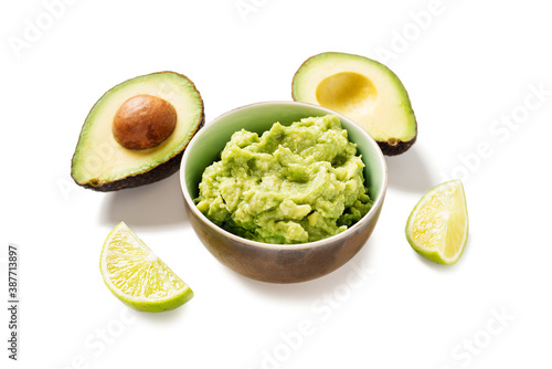 Bowl with guacamole and ripe avocado on white background 
