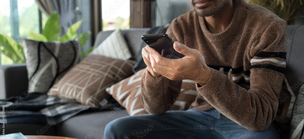 young man using smartphone with application during stay at home, Chat, shopping online, working, connecting, mobile banking concept young man using smartphone with application during stay at home, Chat, shopping online, working, connecting, mobile banking concept