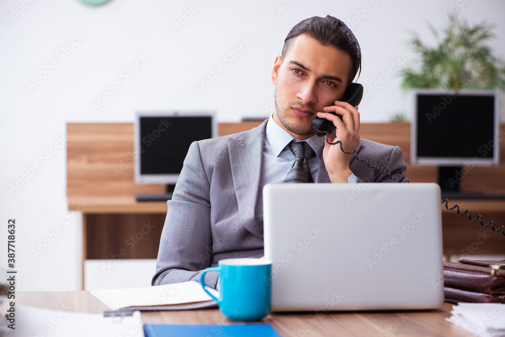 Young male employee unhappy with excessive work Young male employee unhappy with excessive work