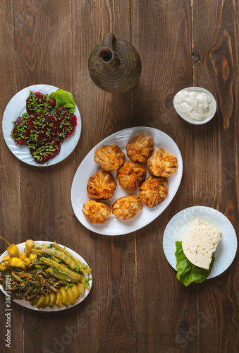 Georgian cuisine foodset from fried dumplings khinkali, wine, cheese, pickles and red salad,on the table. Top view. photo