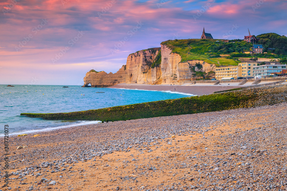 Gravel beach with cliffs and waterfront buildings, Etretat, Normandy, France