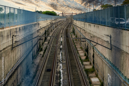 The train tracks descend into the tunnel
