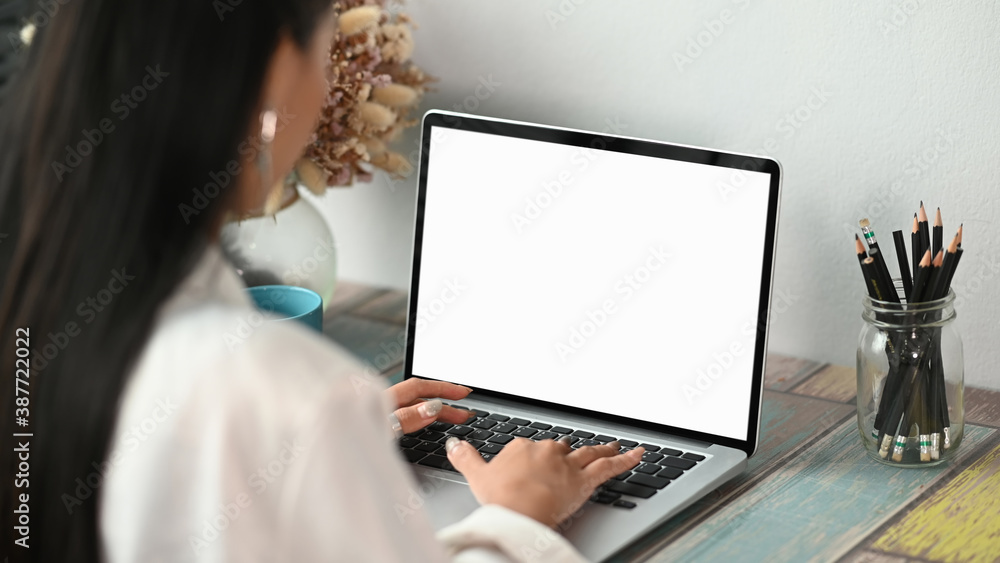 Cropped shot of young Asian businesswoman working on computer laptop in her workplace. Cropped shot of young Asian businesswoman working on computer laptop in her workplace.