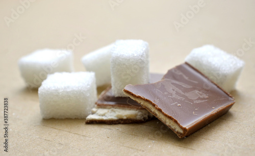 close up of sugar cubes on brown background