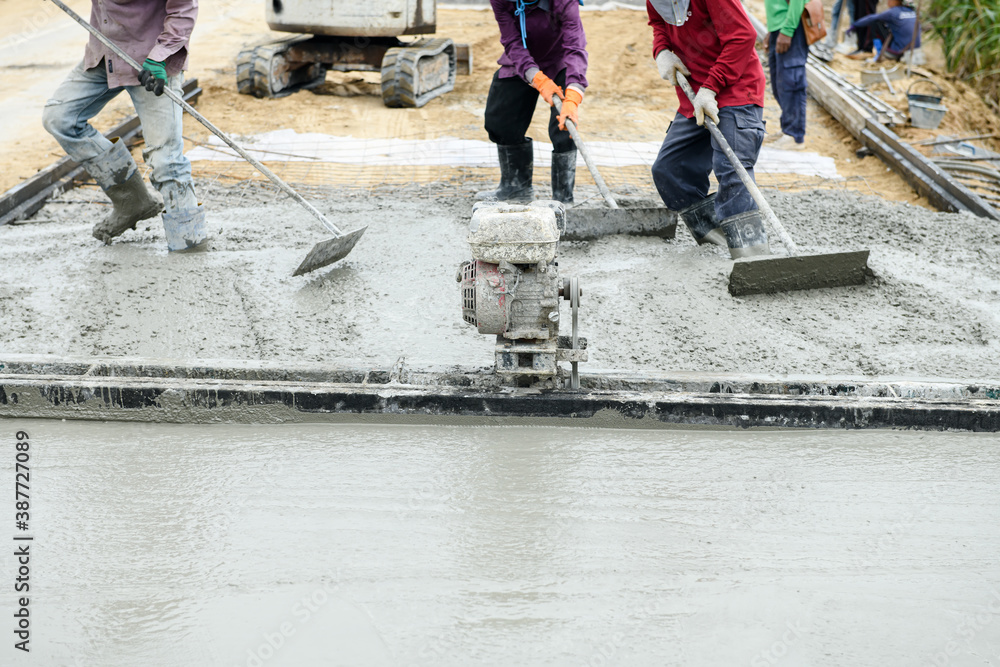 Pouring concrete with worker mix cement at construction site Pouring concrete with worker mix cement at construction site