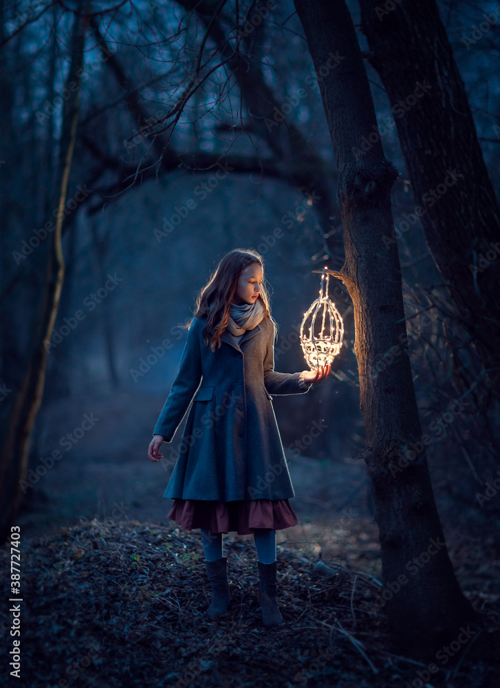 Girl with lantern in the night forest