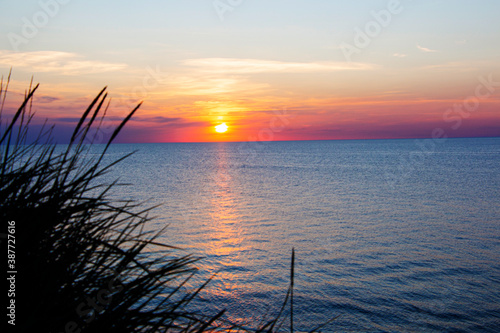 sunset on the sea. The orange color of the sun is hidden behind the horizon of the sea.