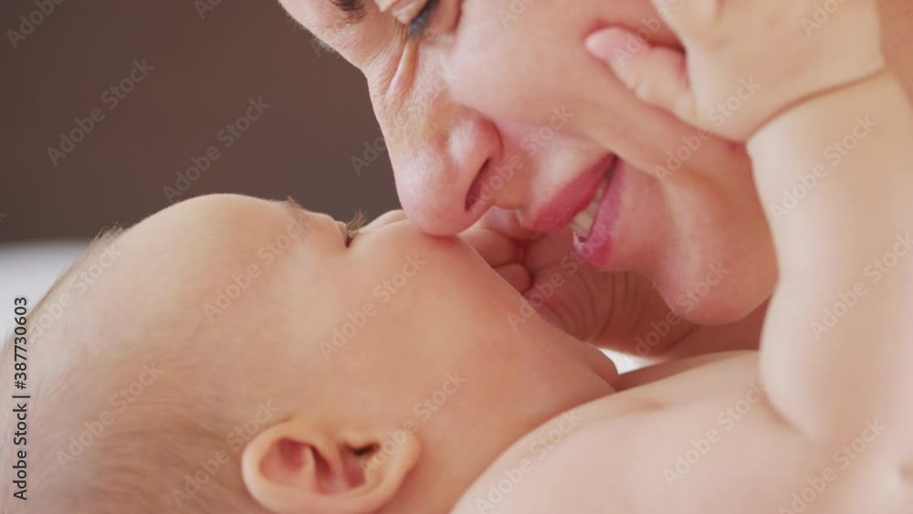 Close up shot of young mother is playing with her newborn baby in a nursery in a morning. Concept of children,baby, parenthood, childhood, life, motherhood. Close up shot of young mother is playing with her newborn baby in a nursery in a morning. Concept of children,baby, parenthood, childhood, life, motherhood.