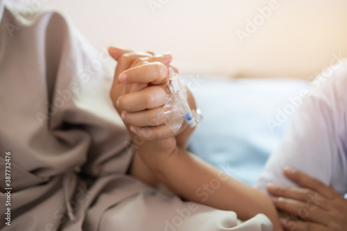 Love hope concept: Daughter Visits mother holding hand for recovering that sick lying on bed in Hospital, looking with cheerful love hopeful, Encouragement comforting Recovering from family healthy