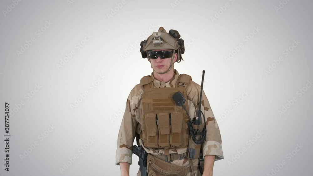 Soldier preparing tactical gear for action battle on gradient background. Soldier preparing tactical gear for action battle on gradient background.
