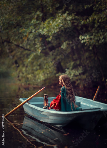 Young woman with lantern in the boat