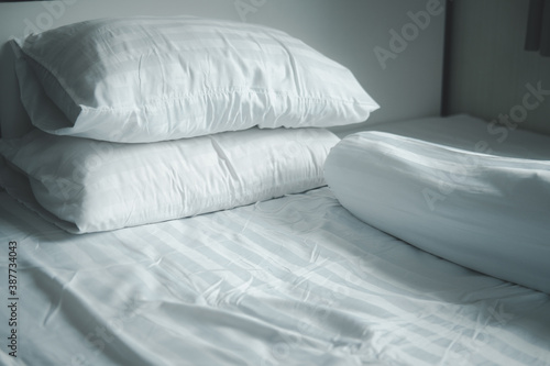 Fotografie White pillow and white bolster on white bed in home