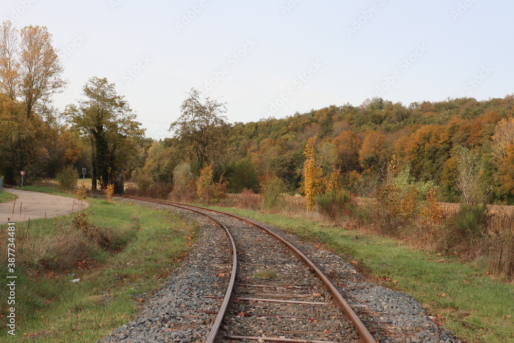 Voie de chemin de fer unique avec traverses en bois de type vignole, au milieu de la campagne en automne, ville de Saint Quentin Fallavier, département de l'Isère, France Voie de chemin de fer unique avec traverses en bois de type vignole, au milieu de la campagne en automne, ville de Saint Quentin Fallavier, département de l'Isère, France