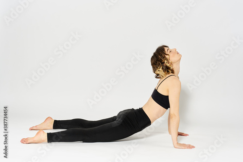 Sportive woman will do the exercise lying on the floor Gymnastics fitness in a bright room