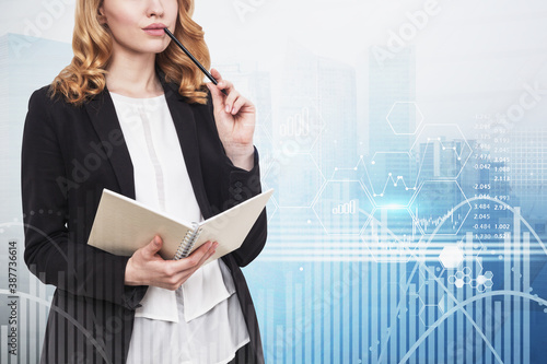 Pensive woman with notebook incity, financial graph photo