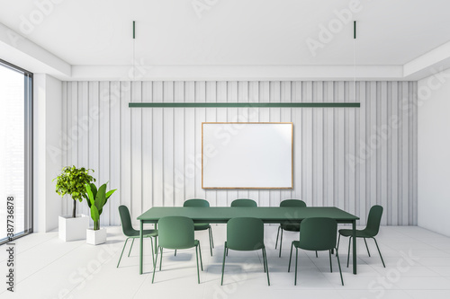 White dining room interior with green table and poster