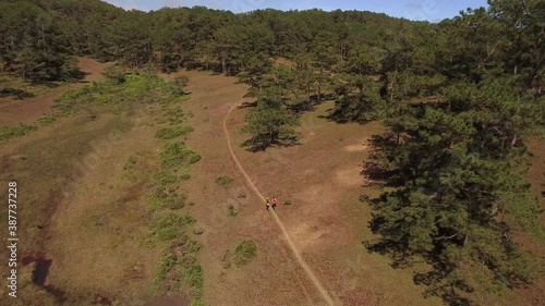 Aerial of young men and women running on mountain hills
