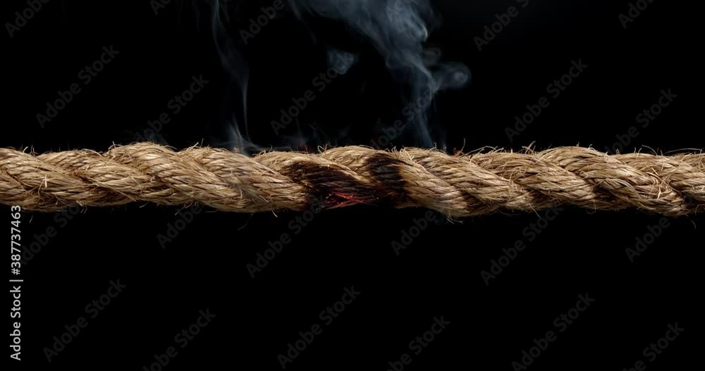 Rope stretched tight and slowly burning apart, finally snapping in two