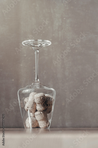 Image of wine corks in a transparent glass on a table in the dust of the sun