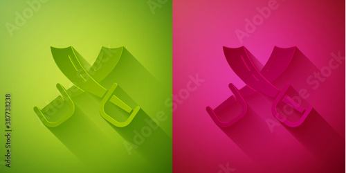 Paper cut Crossed pirate swords icon isolated on green and pink background. Sabre sign. Paper art style. Vector.