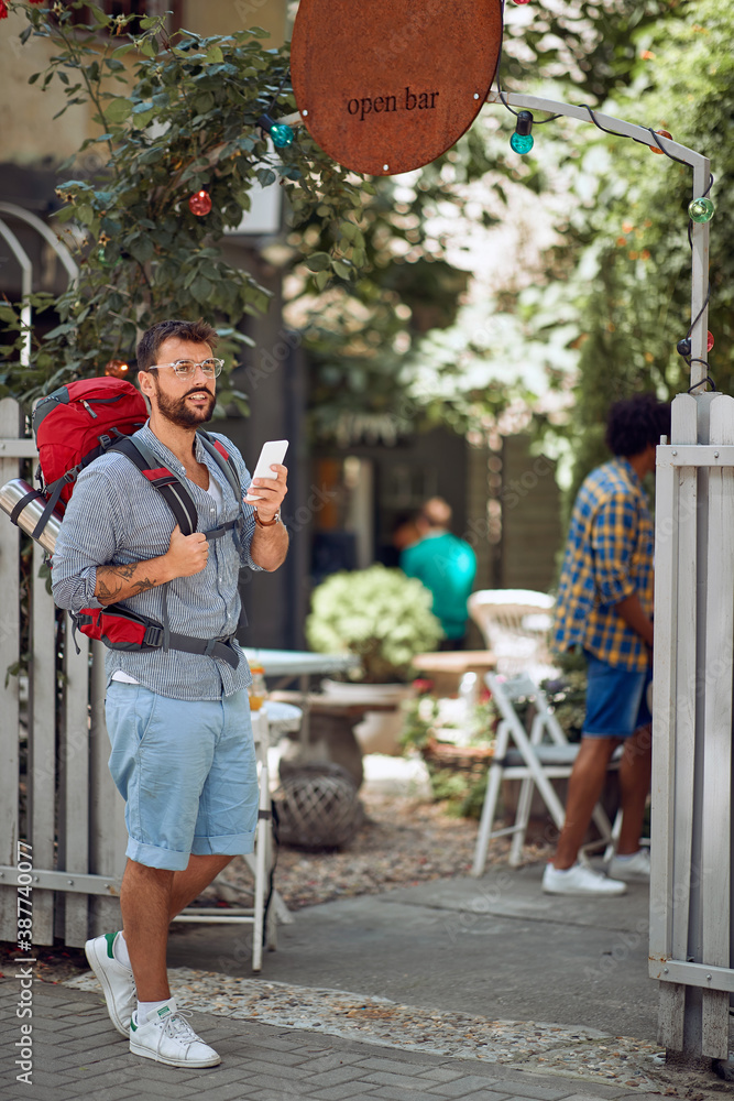 Young male tourist in front of the hostel. Travel, tourism and people concept