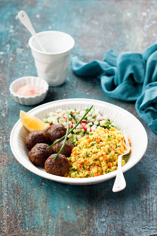 Lamb meatballs with cauliflower rice or couscous and vegetable salad, selective focus Lamb meatballs with cauliflower rice or couscous and vegetable salad, selective focus