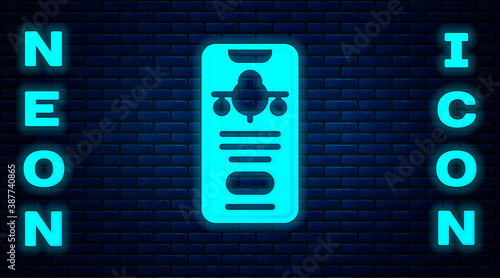 Glowing neon Smartphone with electronic boarding pass airline ticket icon isolated on brick wall background. Passenger plane mobile ticket for web and app. Vector.