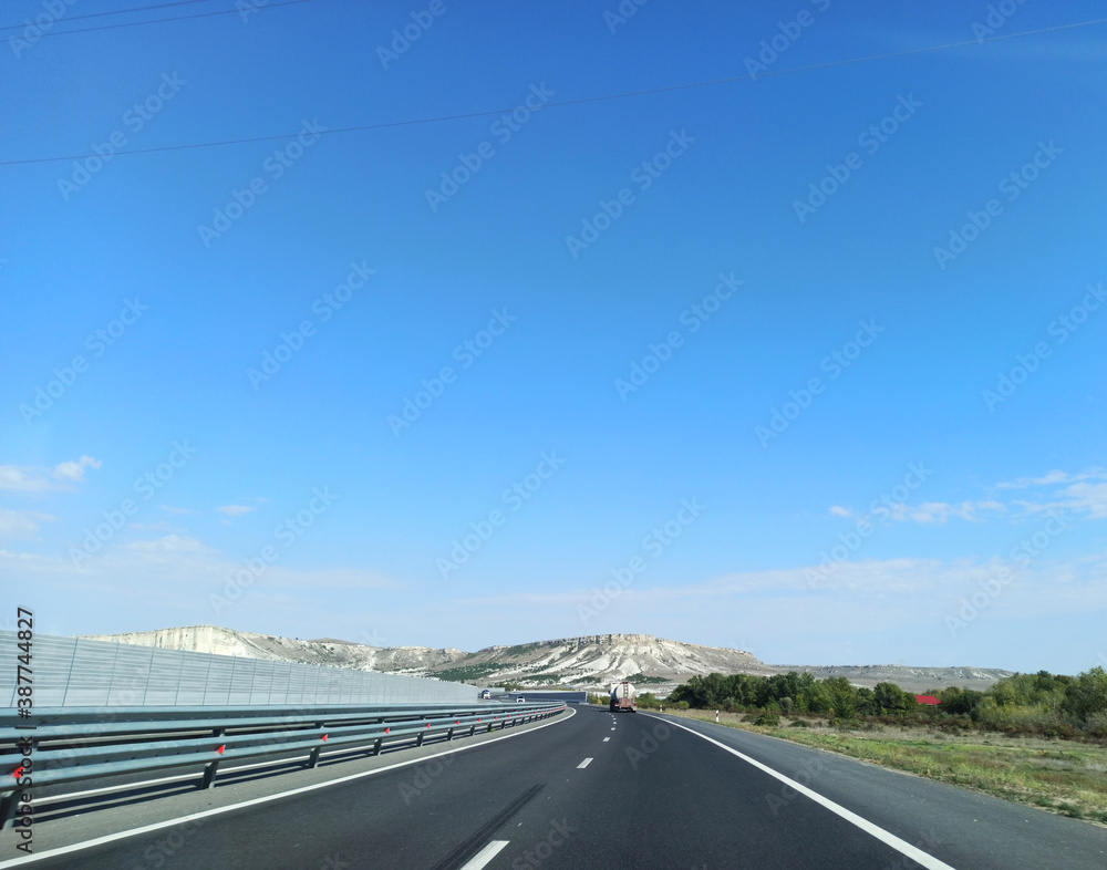 Fototapeta premium Asphalt road along the sea at sunset.