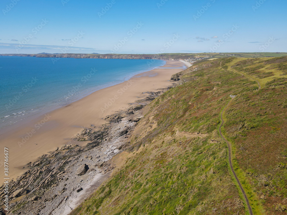 A Drone Image of Newgale Beach, Pembrokeshie, Wales, UK from public land showing stunning coastal views with a light blue ocean. 