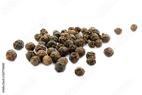 Black pepper isolated on white background, close-up. Spice. Close-up of black pepper on a white background. Píper nígrum. Black peppercorns on a white background. Dry pepper on a white background.