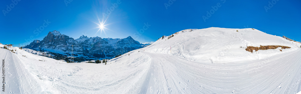 Winter landscape with snow covered peaks seen from the First mountain in Swiss Alps in Grindelwald, Switzerland