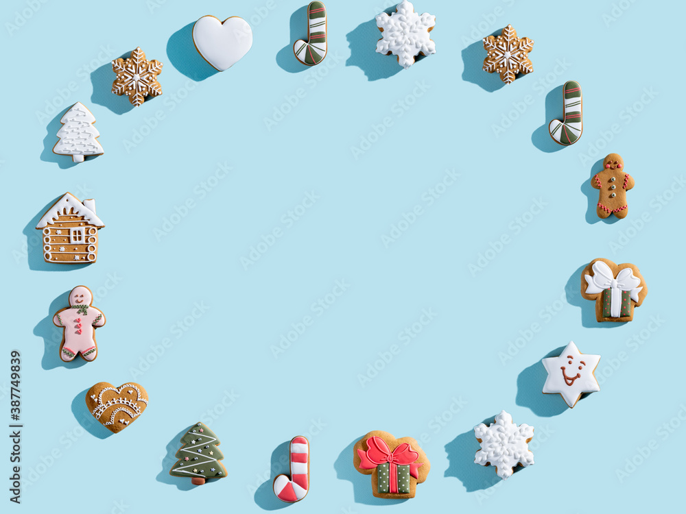 Obraz premium Blue Christmas advertising background. Cookie pattern round frame. Winter holidays bakery food decor. Homemade gingerbread biscuit collection arrangement isolated on light copy space.